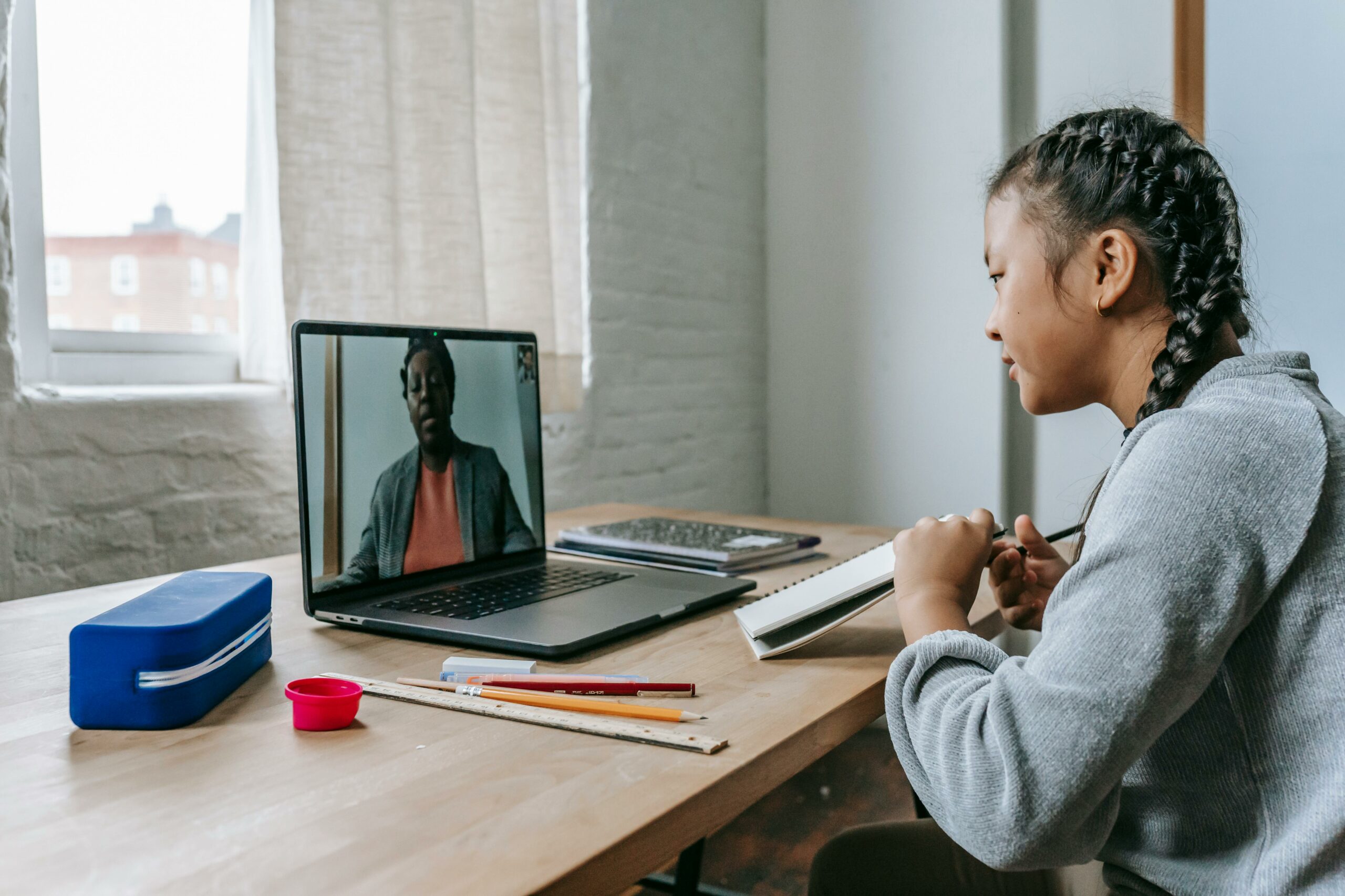 child-talking-to-teacher-through-laptop