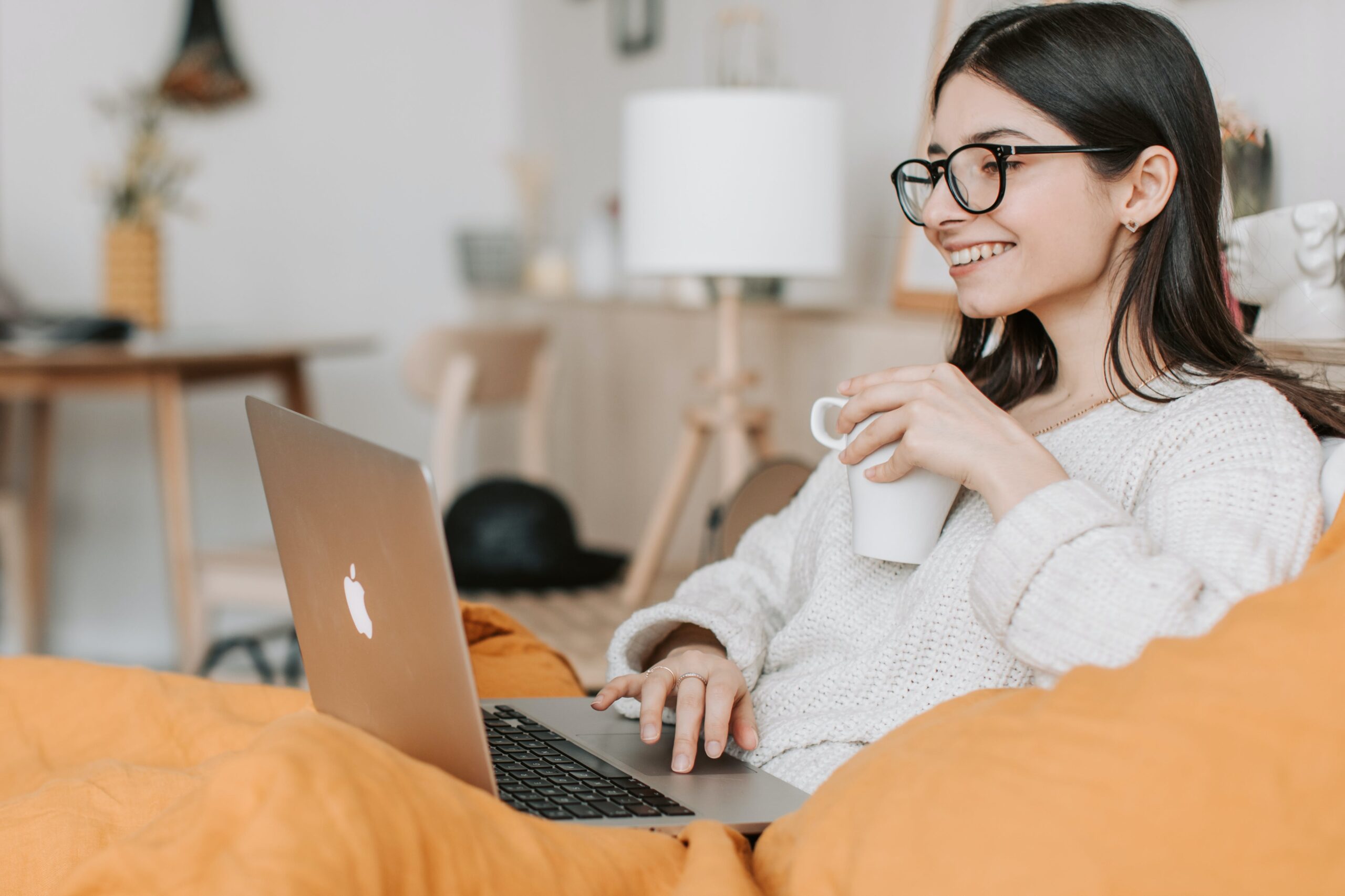 woman-looking-at-laptop-holding-coffee-mug